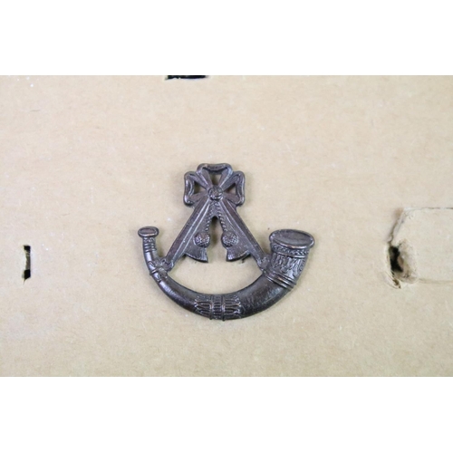 44 - A collection of British military regimental cap and collar badges to include the Somerset Light Infa... 