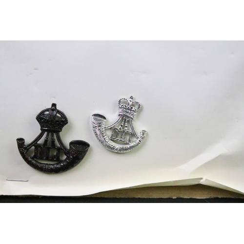 46 - A collection of British military regimental cap and collar badges to include the Lincolnshire regime... 