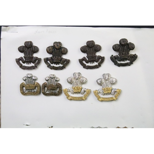 49 - A collection of British military Regimental cap and collar badges to include the East Lancashire Reg... 