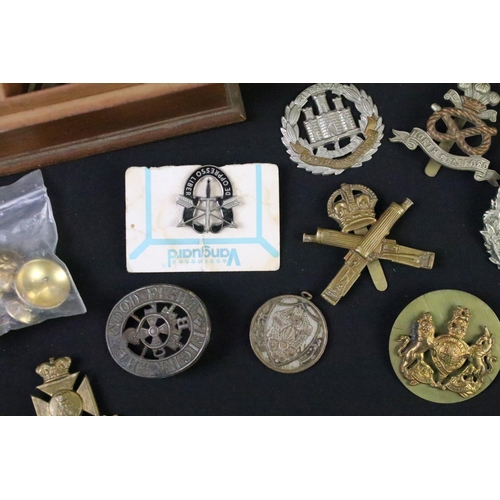 53 - A collection of mainly British Military cap badges, collar badges, medal bars etc.. to include the m... 