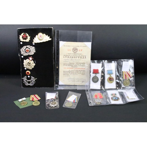 70 - A collection of Russian / CCCP medals and cap badges to include World War Two examples.