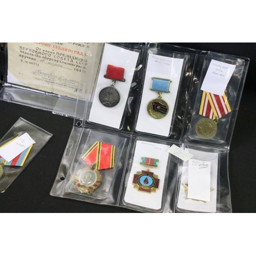 70 - A collection of Russian / CCCP medals and cap badges to include World War Two examples.