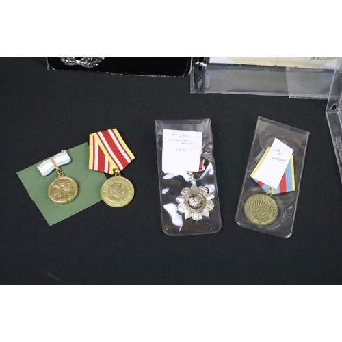 70 - A collection of Russian / CCCP medals and cap badges to include World War Two examples.