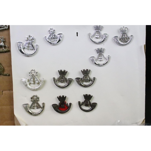 73 - A collection of mainly British and Commonwealth cap and collar badges to include King Crown, Queens ... 