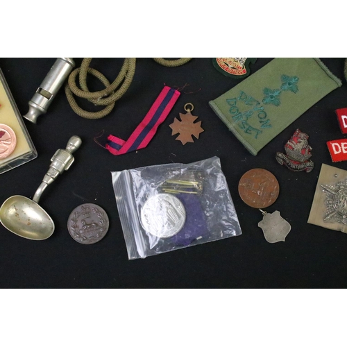 75 - A collection of mixed military collectables to include cloth badges, shoulder titles, lanyards, ciga... 