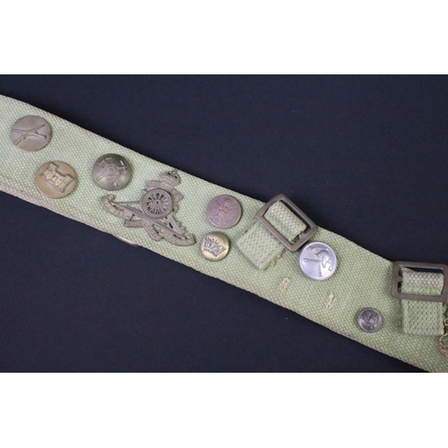 76 - A military webbing belt with attached buttons and cap badges.