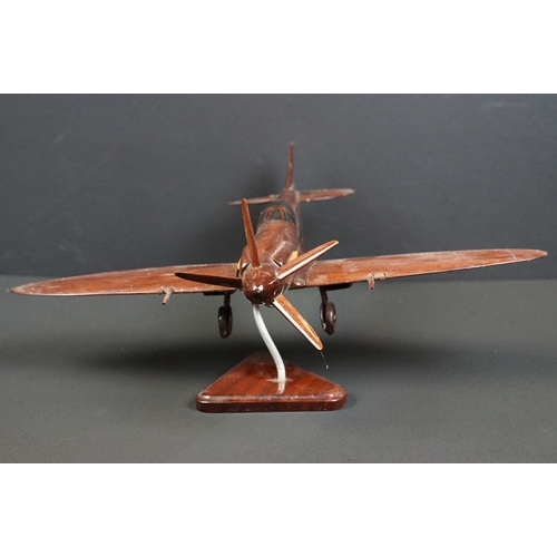 286 - A carved wooden model of a RAF Spitfire on wooden plinth