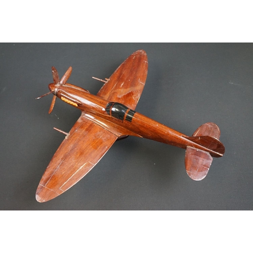 286 - A carved wooden model of a RAF Spitfire on wooden plinth