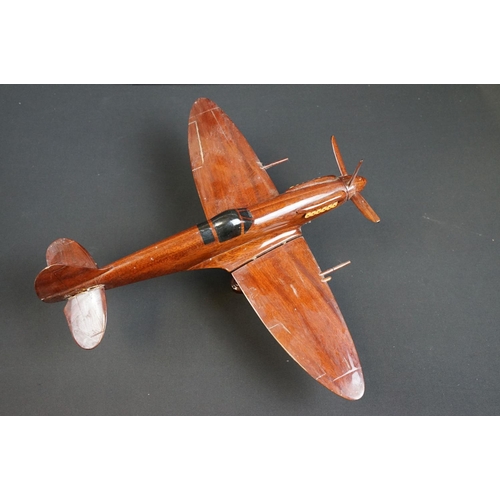 286 - A carved wooden model of a RAF Spitfire on wooden plinth