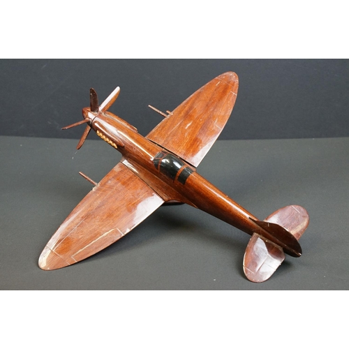 286 - A carved wooden model of a RAF Spitfire on wooden plinth