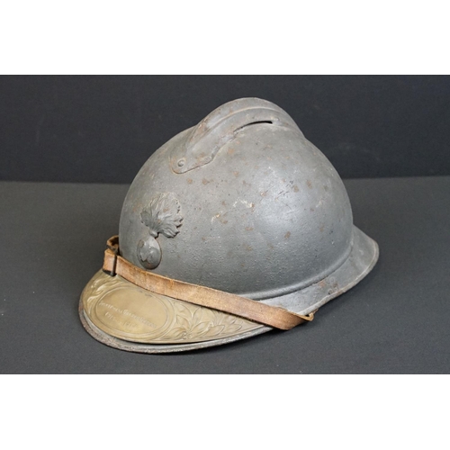 201 - A World War One French Adrian Helmet complete with liner and veterans peak plaque.