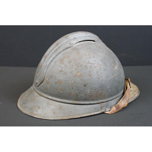 201 - A World War One French Adrian Helmet complete with liner and veterans peak plaque.