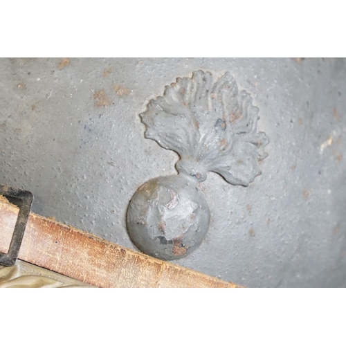 201 - A World War One French Adrian Helmet complete with liner and veterans peak plaque.