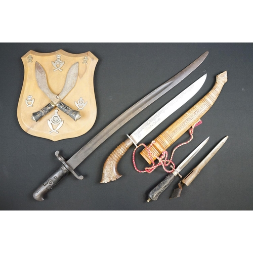 233 - A small group of knives to include a military bayonet, two Arabic daggers and a pair of mounted kukr... 