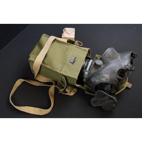 31 - A box of mixed military collectables to include webbing belt with pistol holster, respirator bag and... 