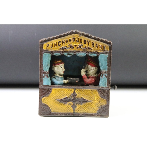 141 - Two reproduction cast iron money boxes to include a Punch and Judy box and an Uncle Sam example. Lar... 