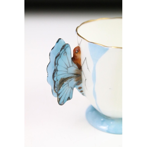 54 - Aynsley Art Deco tea cup and saucer having a butterfly formed handle, gilt rims and blue hand painte... 