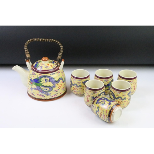 64 - 20th Century Chinese tea set including six tea cups and teapot, all being decorated with blue dragon... 