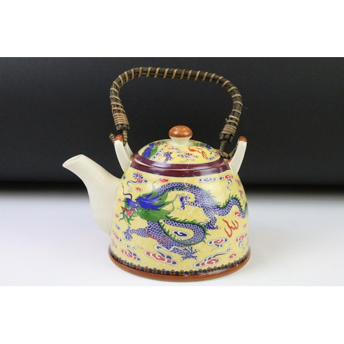 64 - 20th Century Chinese tea set including six tea cups and teapot, all being decorated with blue dragon... 