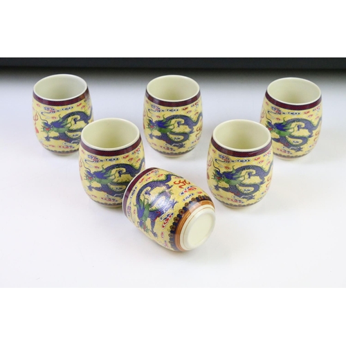 64 - 20th Century Chinese tea set including six tea cups and teapot, all being decorated with blue dragon... 