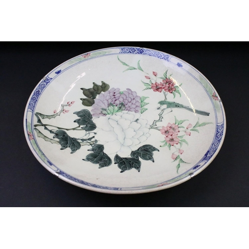 67 - Pair of Chinese hand painted wall charger plates being decorated with floral sprays and geometric bo... 