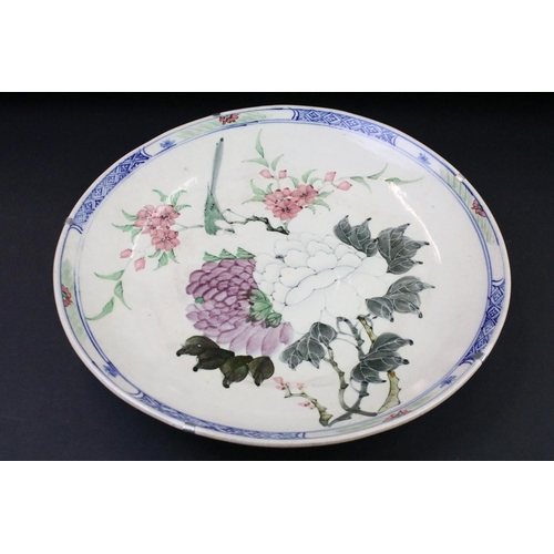 67 - Pair of Chinese hand painted wall charger plates being decorated with floral sprays and geometric bo... 