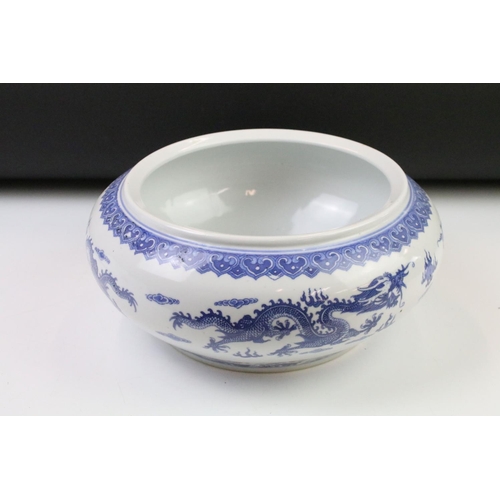 75 - 20th Century Chinese blue and white bowl being hand painted with dragons and with four character mar... 