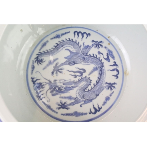 75 - 20th Century Chinese blue and white bowl being hand painted with dragons and with four character mar... 