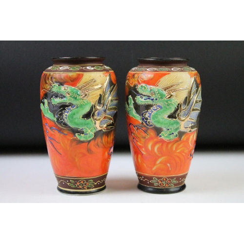 78 - Pair of Japanese Porcelain hand painted Vases decorated in relief with dragons on an orange ground, ... 