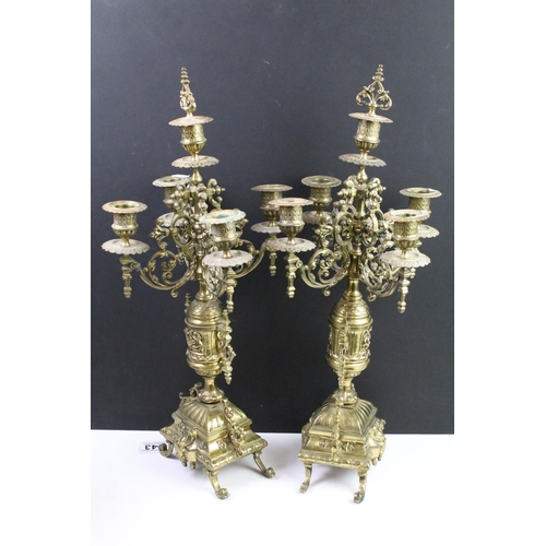 143 - Cast brass clock garniture set clock of scrolling form, the clock with pierced design, cream dial an... 