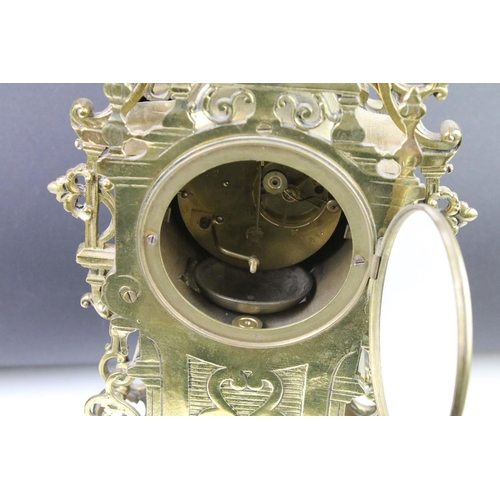 143 - Cast brass clock garniture set clock of scrolling form, the clock with pierced design, cream dial an... 