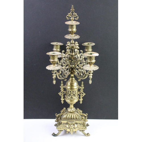 143 - Cast brass clock garniture set clock of scrolling form, the clock with pierced design, cream dial an... 