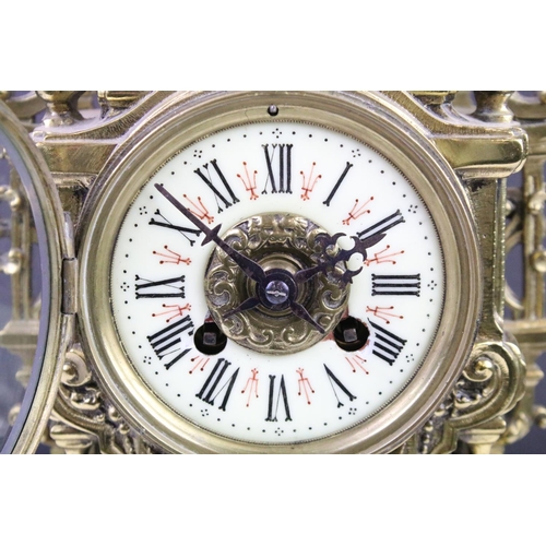 143 - Cast brass clock garniture set clock of scrolling form, the clock with pierced design, cream dial an... 