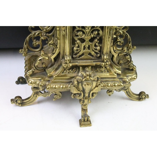 143 - Cast brass clock garniture set clock of scrolling form, the clock with pierced design, cream dial an... 