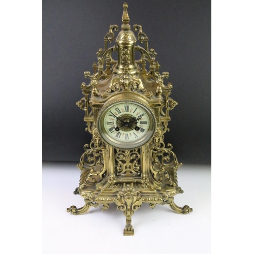 143 - Cast brass clock garniture set clock of scrolling form, the clock with pierced design, cream dial an... 