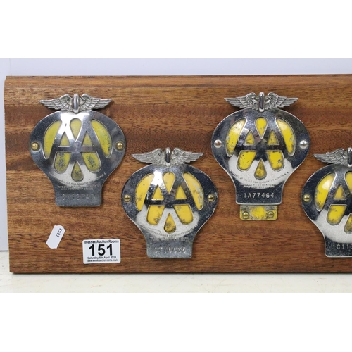 151 - Automobilia - A wall display of nine AA grill badges and AA key, all mounted on a wooden panel. (Mea... 