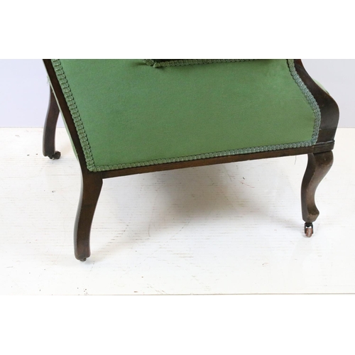 646 - Victorian mahogany armchair, with carved top rail, upholstered in green with button back, on cabriol... 