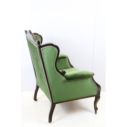 646 - Victorian mahogany armchair, with carved top rail, upholstered in green with button back, on cabriol... 