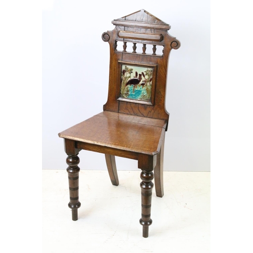 649 - Victorian oak hall chair with Majolica inset tile to back, 90cm high x 44cm wide x 36cm deep