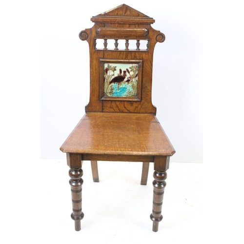 649 - Victorian oak hall chair with Majolica inset tile to back, 90cm high x 44cm wide x 36cm deep