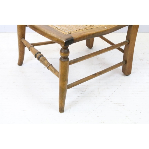 652 - Edwardian low chair, the top rail carved with a flower and foliage, above spindles, the back and sea... 