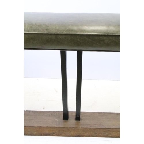 657 - Green leather club fender, the cushioned green leather top above black metal supports and oak base, ... 