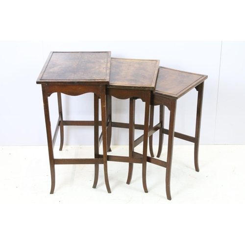 657A - Nest of three walnut coffee tables, the largest, 61cm high x 44cm wide x 33cm deep
