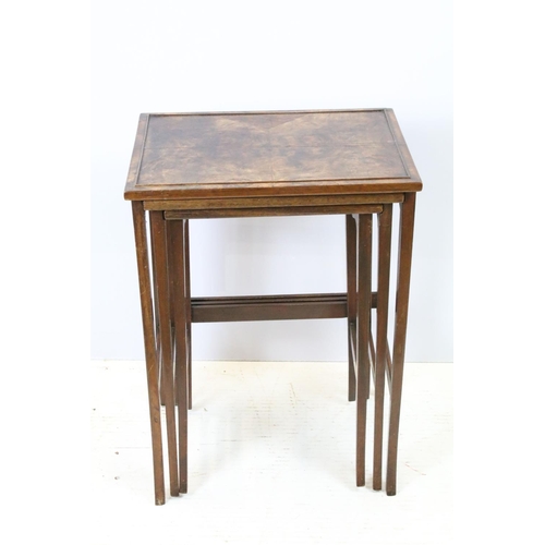 657A - Nest of three walnut coffee tables, the largest, 61cm high x 44cm wide x 33cm deep