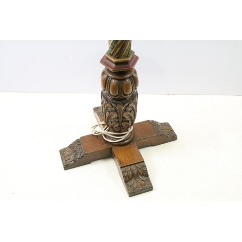 669A - 20th century substantial carved oak standard lamp, the four feet carved with flowers and leaves, the... 