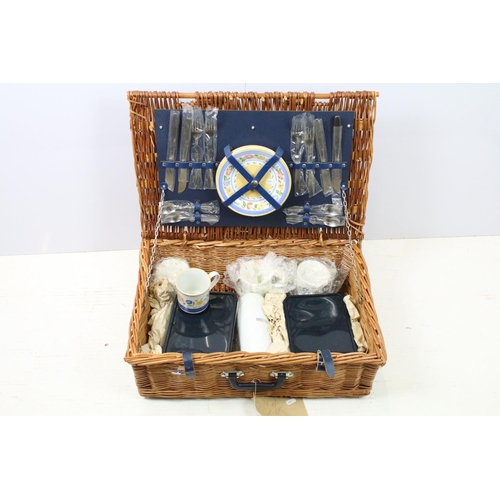 672 - Wicker picnic hamper containing a four piece place setting