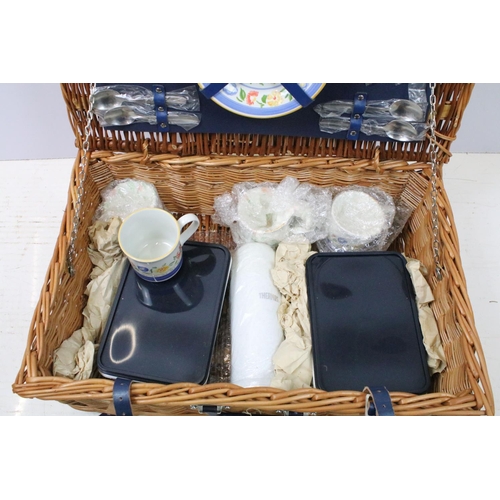 672 - Wicker picnic hamper containing a four piece place setting
