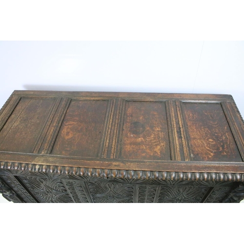 676 - 19th century carved oak chest of substantial proportions, the four panelled lid above carved front, ... 
