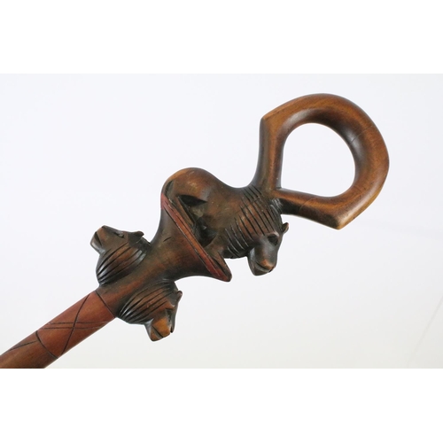 129 - Hand carved African walking stick with lion masks, together with a vintage Bavarian walking stick wi... 