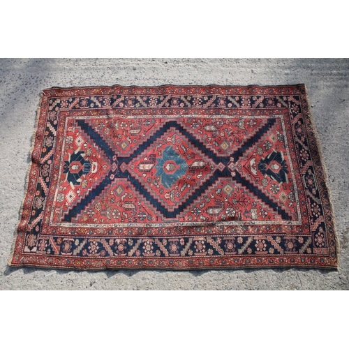 669 - Middle Eastern red ground rug, with central medallion and two half medallions, 197cm x 132cm